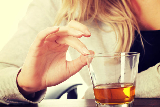 Alcohol Addiction Treatment- The Key Things to Know Woman holding alcohol glass thinking about alcohol addiction treatment