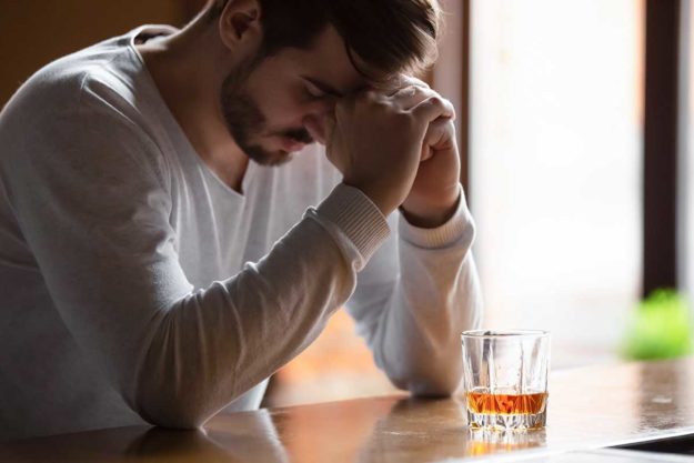 functioning alcoholic guy sitting at a bar who is a functioning alcoholic